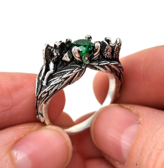 Sterling siler DND D&D engagement ring with 2 angels sculptures with wings emerald gemstone and dnd character art for ttrpg fans.