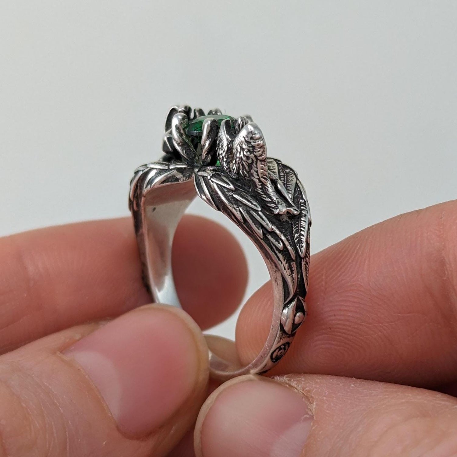 Sterling siler DND D&D engagement ring with 2 angels sculptures with wings emerald gemstone and dnd character art for ttrpg fans.